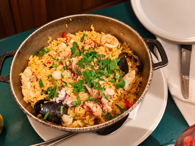 Iron pot of yellow rice with mussels, shrimp, calamari and cilantro